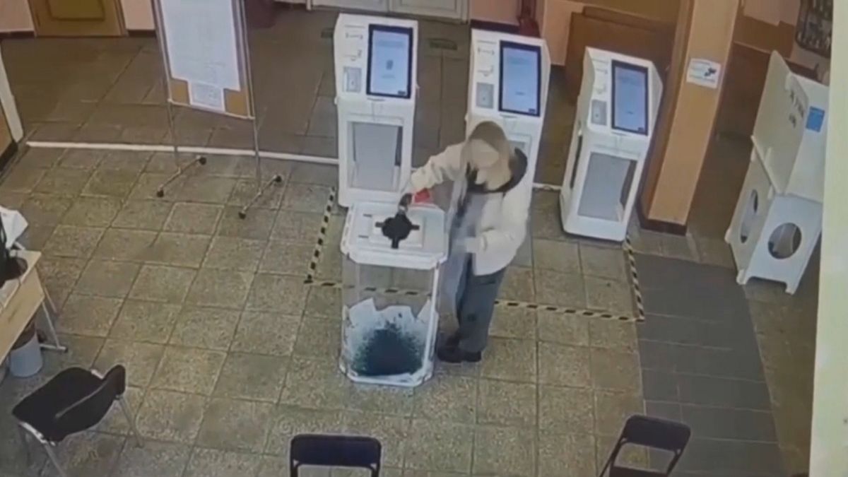 Una votante destruye los votos con tinte en un colegio electoral ruso, 15 de marzo de 2024.