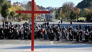  Piskoposlar, Fransa'nın güneybatısındaki Lourdes kentinde bulunan Notre-Dame-du-Rosaire bazilikasının ön avlusunda diz çöküyor. 6 Kasım 2021 