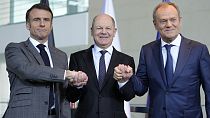Bundeskanzler Olaf Scholz, Frankreichs Präsident Emmanuel Macron, und Polens Premierminister Donald Tusk schütteln bei einer Pressekonferenz in Berlin, 15. März 2024.