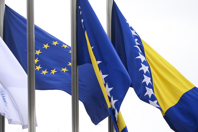 European Union flag flutters next to the flag of Bosnia and Herzegovina in front of the Council of Ministers building in Sarajevo, Bosnia-Herzegovina