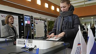 Eine russische Wählerin scannt ihren Stimmzettel ein. Sankt Petersburg, 16. März 2024