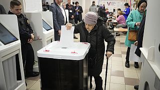 An elderly woman casts a ballot during a presidential election in Moscow, Russia, Saturday, March 16, 2024. 