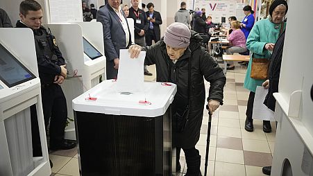 An elderly woman casts a ballot during a presidential election in Moscow, Russia, Saturday, March 16, 2024. 