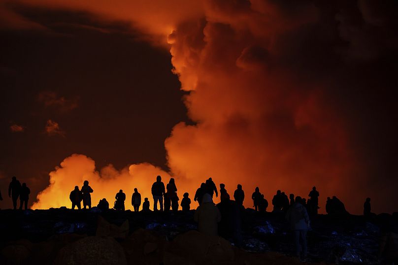 سكان محليون يشاهدون التدفق البركاني عن بعد