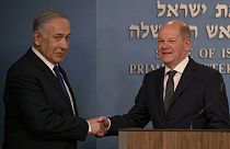 El primer ministro israelí, Benjamin Netanyahu da la mano al canciller alemán, Olaf Scholz