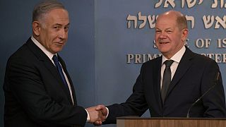 El primer ministro israelí, Benjamin Netanyahu da la mano al canciller alemán, Olaf Scholz