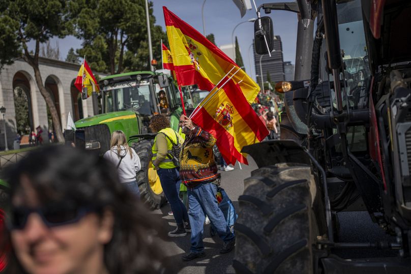 A man sells Spanish flags during a farmers protest in Madrid, Spain, Sunday, March 17, 2024.