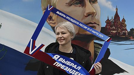 Eine Frau posiert mit einem Rahmen mit der Aufschrift "Ich habe den Präsidenten gewählt" in einem Wahllokal in Donezk