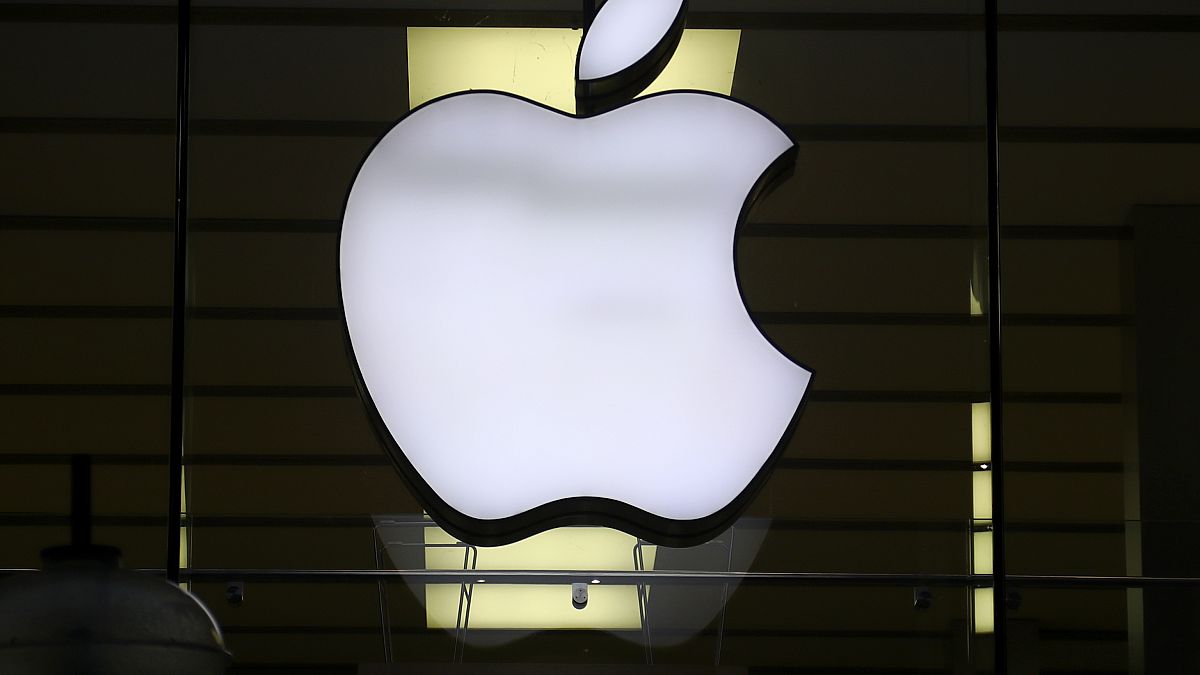 The Apple logo is illuminated at a store in the city center of Munich, Germany, Dec. 16, 2020. 
