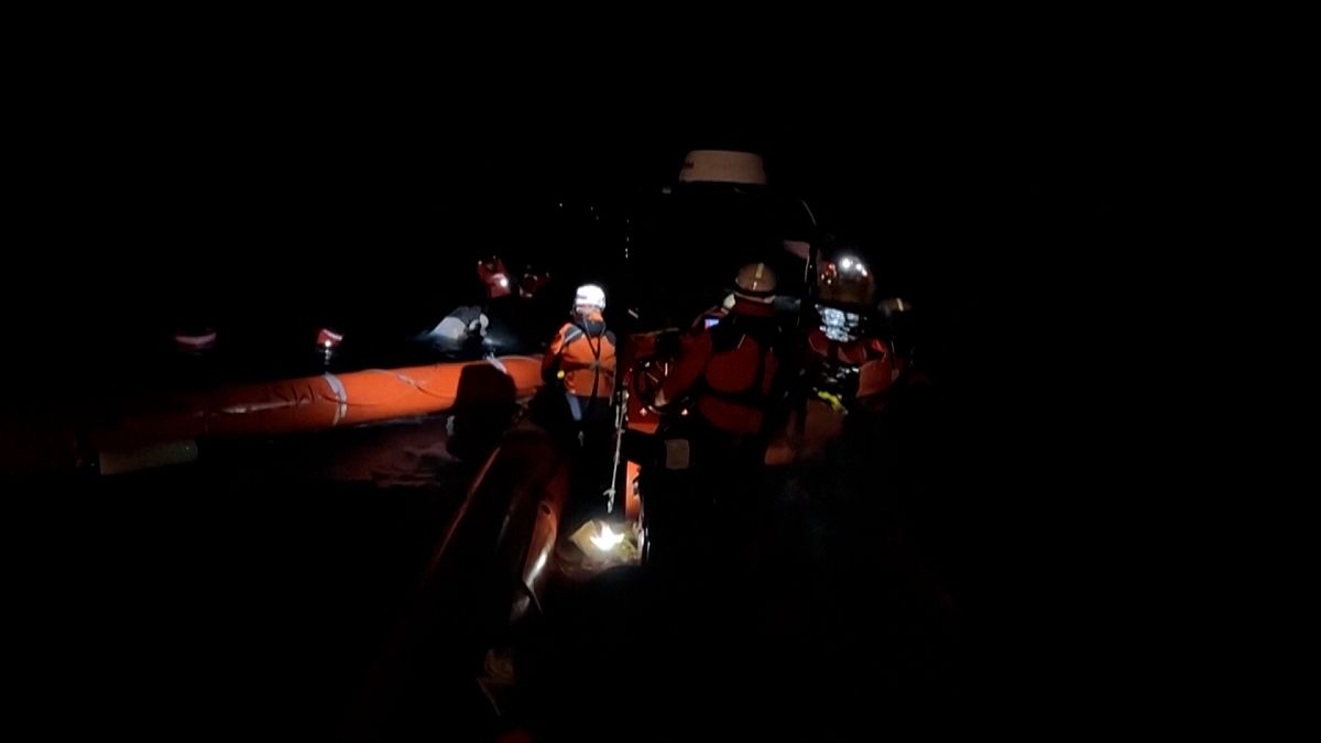 Imagen de una operación de rescate de una embarcación con inmigrantes a la deriva, durante la noche, en aguas del mar Mediterráneo.