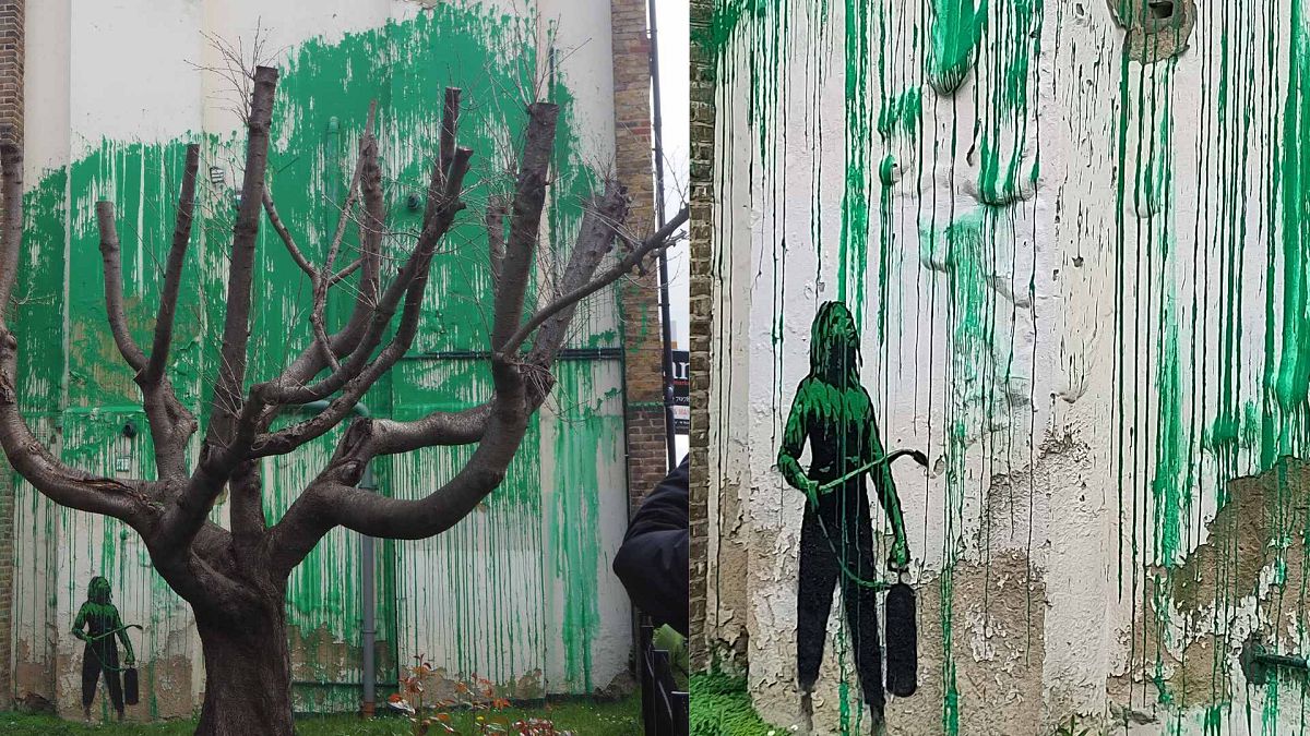 The artwork in the Finsbury Park neighborhood covers the wall of a building and shows a small figure holding a pressure hose beside a large cherry tree. 18 March 2024