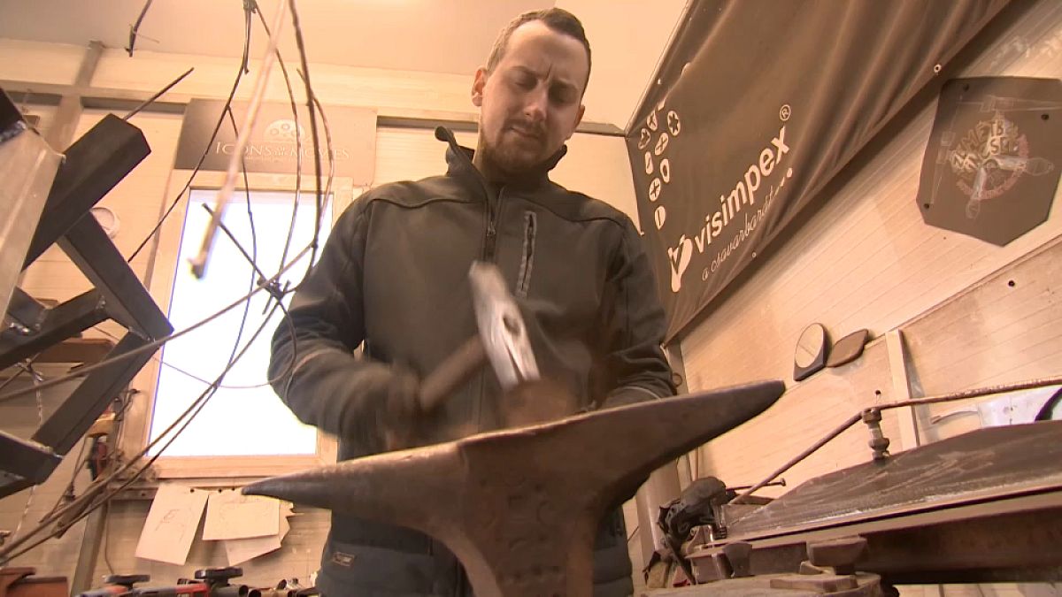 Antigo reparador de automóveis a esculpir metal descartável na sua oficina nas montanhas da Hungria.