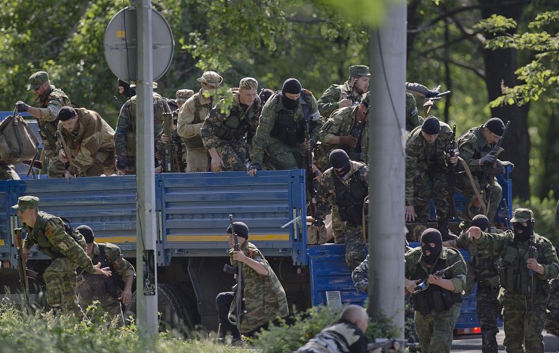 Des hommes armés pro-russes prennent position près de de l'aéroport à l'extérieur de Donetsk, en Ukraine, le lundi 26 mai 2014.