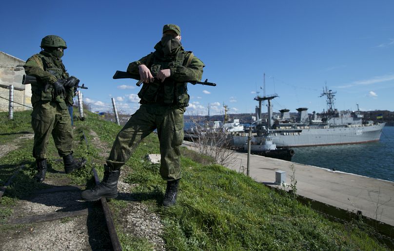 Des soldats russes gardent une jetée où sont amarrés deux bateaux ukrainiens, à Sébastopol, en Ukraine, le 5 mars 2014.