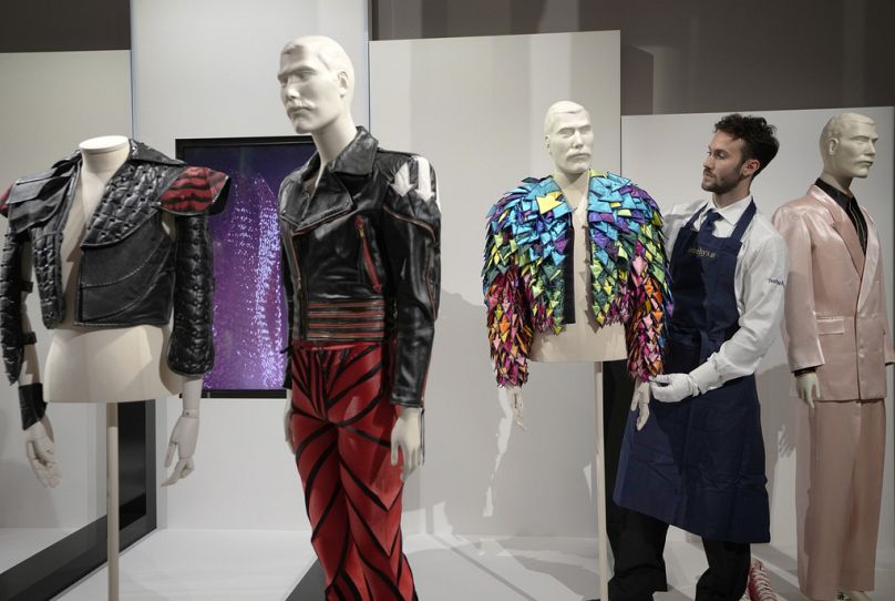 A Sotheby's handler displays a 'Rainbow Coloured Satin Arrow Applique Jacket from 1982' at Sotheby's auction rooms in London, Thursday, Aug. 3, 2023.