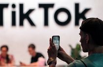 A visitor takes a photo at the TikTok stand at the Gamescom gaming fair in Cologne, Germany.