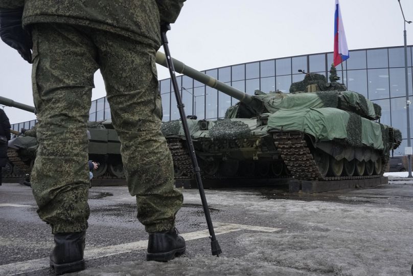 A Russian soldier stands next to a T-90 tank at a weapons exhibition during the 'Russians Change the World' patriotic festival in St Petersburg, February 2024