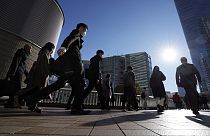 FILE - Commuters walk in a passageway during a rush hour at Shinagawa Station Wednesday, Feb. 14, 2024, in Tokyo.