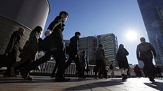 FILE - Commuters walk in a passageway during a rush hour at Shinagawa Station Wednesday, Feb. 14, 2024, in Tokyo.