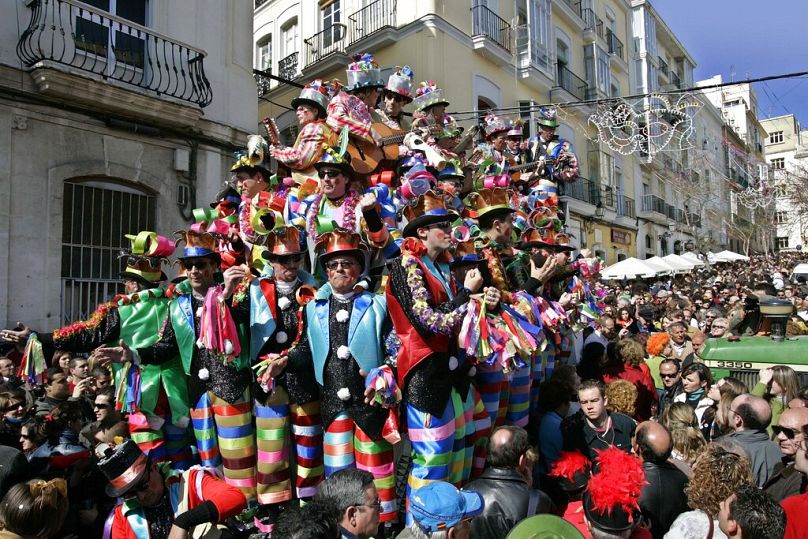 A float of carnival revelers is towed along a packed street in Cádiz, southern Spain.