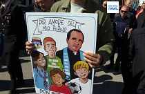 Un cartellone commemorativo raffigura don Peppe Diana insieme ai giovani