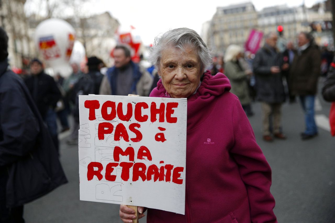 An elderly pensioner holds a placard reading "hands off my pension" during a demonstration in Paris, France, Thursday, March 15, 2018.