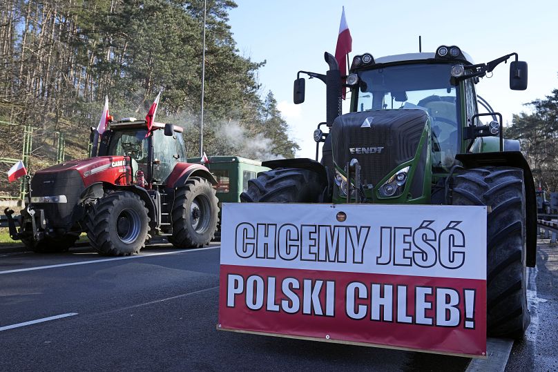 Tractors with a sing reading "We want to eat Polish bread!" line up to block a road near the German border in Swiecko at Slubice, Poland, Tuesday, March 19, 2024.