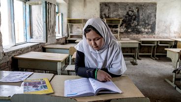 A girl reads a book in her classroom on the first day of the new school year in Kabul.