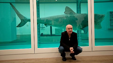 Damien Hirst beside the 1991 piece "The Physical Impossibility of Death in the Mind of Someone Living"