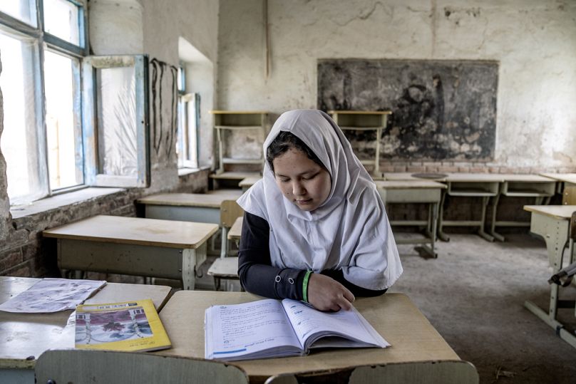 A girl reads a book in her classroom on the first day of the new school year, in Kabul, March 2023