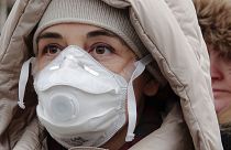 Женщина в маске на лице принимает участие в акции протеста против загрязнения воздуха в Сараево, Босния, 20 января 2020 года.
