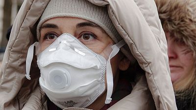 Eine Frau mit Gesichtsmaske nimmt an einem Protest gegen die Luftverschmutzung in Sarajevo, Bosnien-Herzegowina, am 20. Januar 2020 teil.