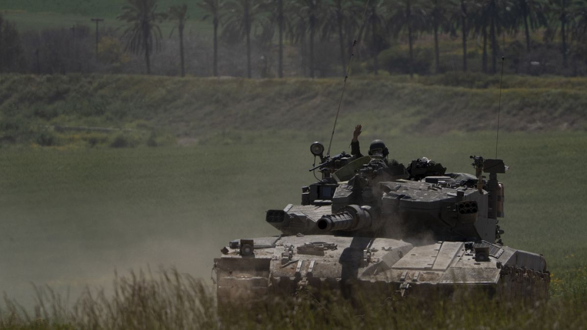 Soldados israelíes se mueven encima de un tanque cerca de la frontera entre Israel y Gaza, visto desde el sur de Israel, el miércoles 20 de marzo de 2024.