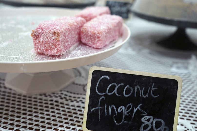 Coconut fingers, a traditional celebration dessert of iced sponge cake dusted with coconut, are displayed at a restaurant on the island