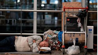 A homeless man sleeps near his belongings at the Jorge Newbery international airport, commonly known as Aeroparque, in Buenos Aires, Argentina, Thursday, April 6, 2023.