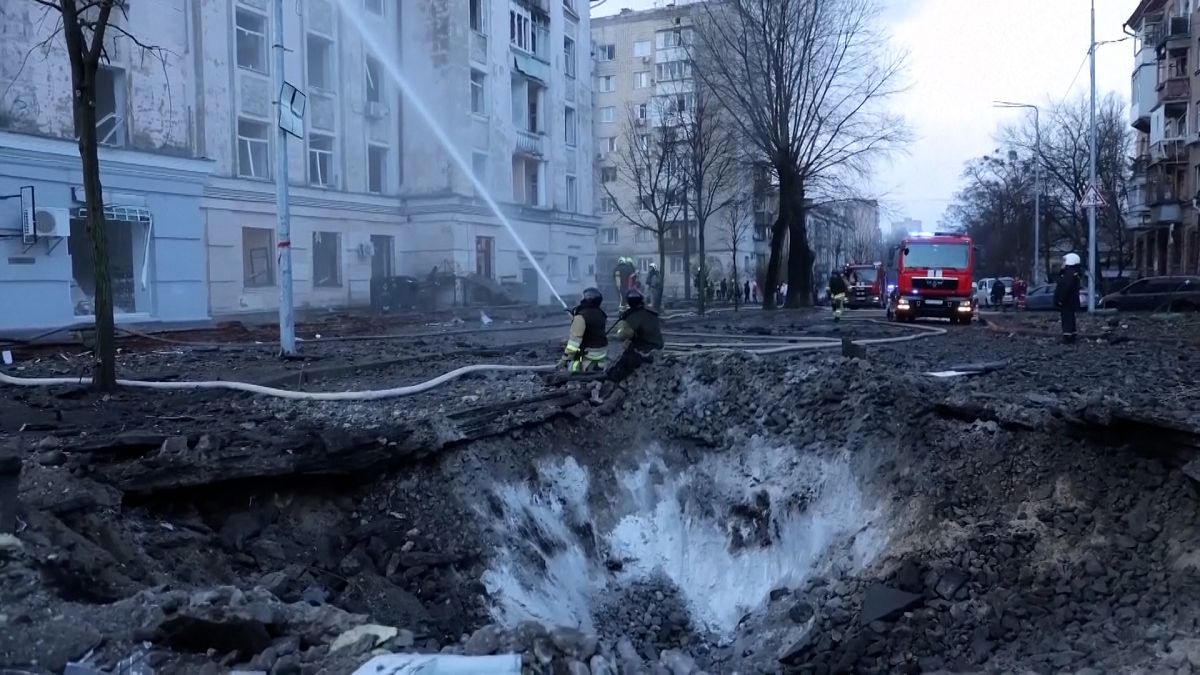 Firefighters work near the crater at the site after a Russian attack in Kyiv, Ukraine, Thursday, March 21, 2024