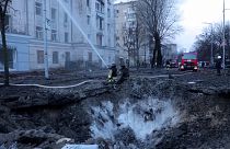 Firefighters work near the crater at the site after a Russian attack in Kyiv, Ukraine, Thursday, March 21, 2024