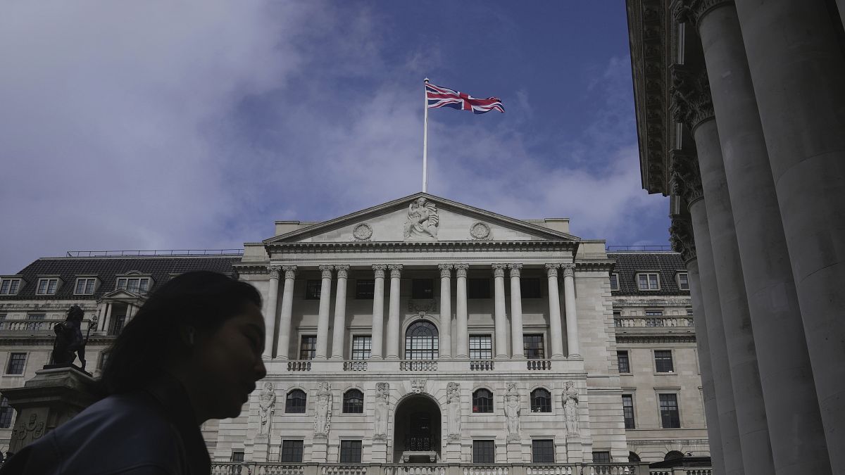 A woman walks in front of the Bank of England, at the financial district in London, on March 23, 2023. 