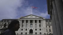 A woman walks in front of the Bank of England, at the financial district in London, on March 23, 2023. 