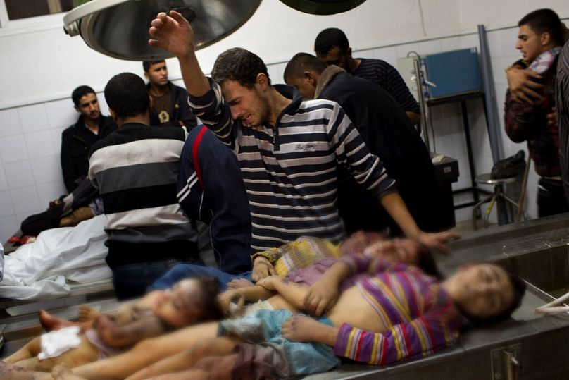 İsrail'in Gazze saldırılarında öldürülen çocukların başında ağlayan bir kişi. Şifa Hastanesi / Gazze