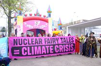 Anti-nuclear campaigners stage a protest as government leaders gather in Brussels to promote a global nuclear revival.