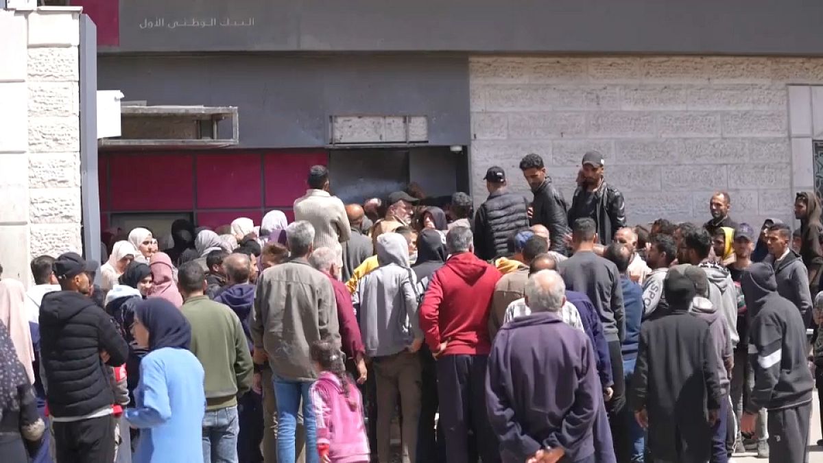 فلسطينيون يحتشدون أمام أحد البنوك في دير البلح للحصول على القليل من المال 