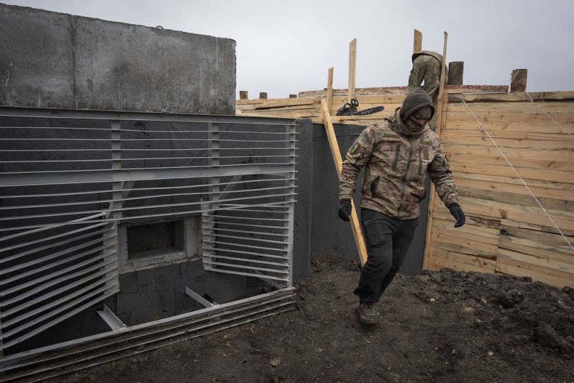 Des ouvriers ukrainiens construisent la ligne de défense fortifiée dans la région de Kharkiv, en Ukraine, le jeudi 21 mars 2024.