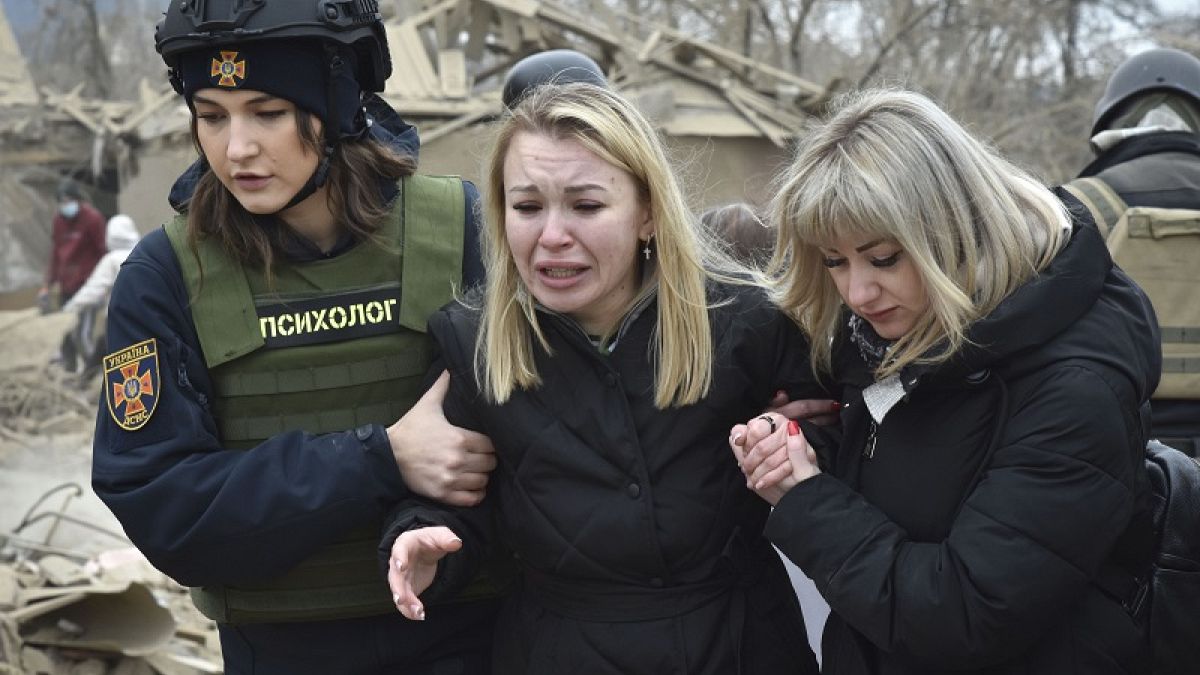 Un servicio de apoyo psicológico de emergencia consuela a una mujer en el lugar del ataque aéreo ruso, en Zaporizhzhia, Ucrania, el viernes 22 de marzo de 2024