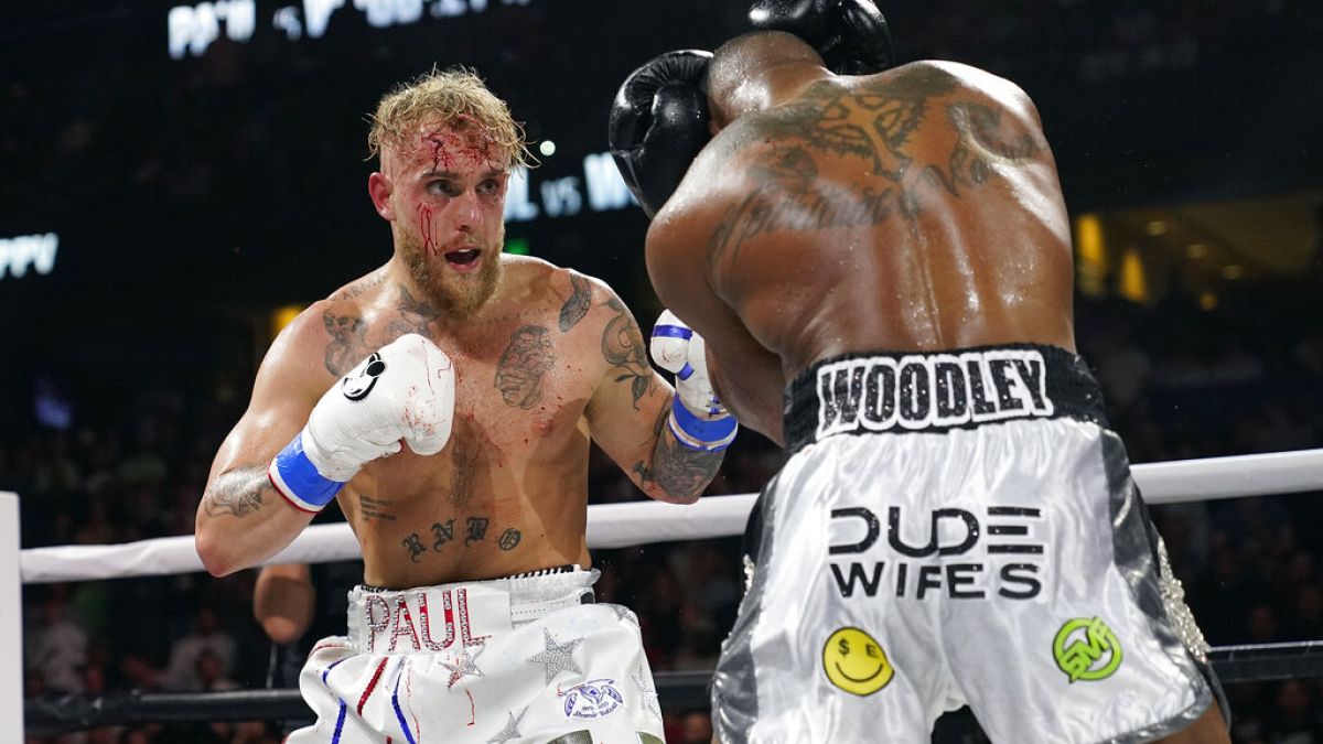 Jake Paul, left, punches Tyron Woodley during the second round of a Cruiserweight fight Sunday, Dec. 19, 2021,