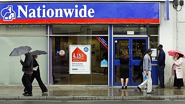 People queue up as they wait for a branch of the Nationwide Building Society to open in Tooting, south London, Wednesday May 27, 2009.