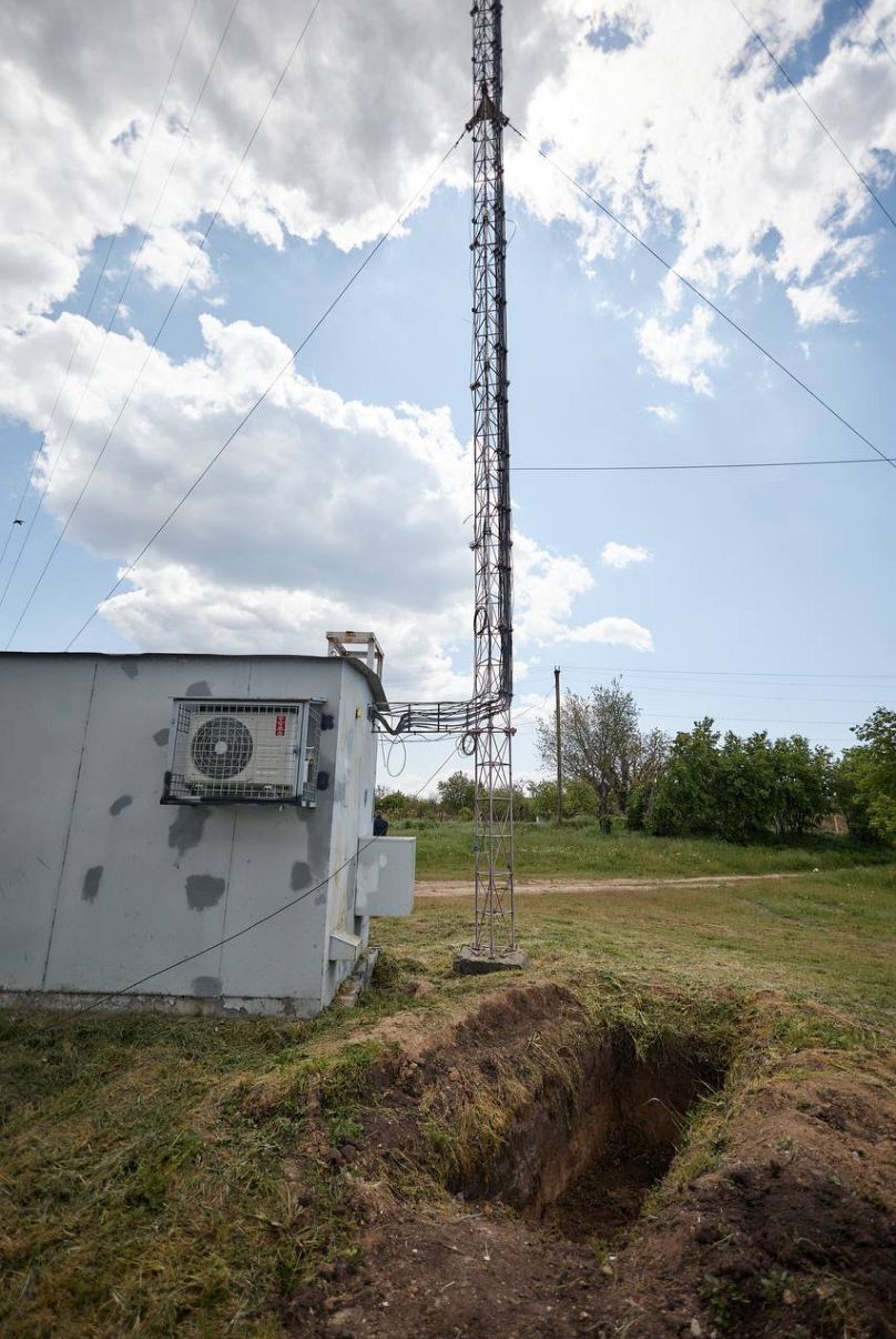 Engineers dug a trench next to a cell tower to conduct repairs in Lyman, Ukraine