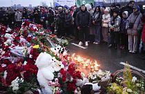 People gather to lay flowers and light candles next to the Crocus City Hall, on the western edge of Moscow, Russia, Saturday, 23 March, 2024. 