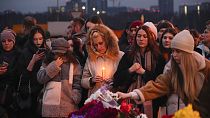Neben der Crocus-City-Hall am westlichen Stadtrand von Moskau legen Menschen Blumen nieder und zünden Kerzen an, 23. März 2024.