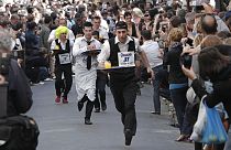 FILE- People dressed as waiters carry trays of drinks as they take part in a race through the streets of Paris, 15 May, 2011. 